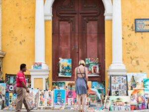 Turistas frente a una exhibición de arte al aire libre en Cartagena, ideal para quienes buscan experiencias culturales en un bus city tour.