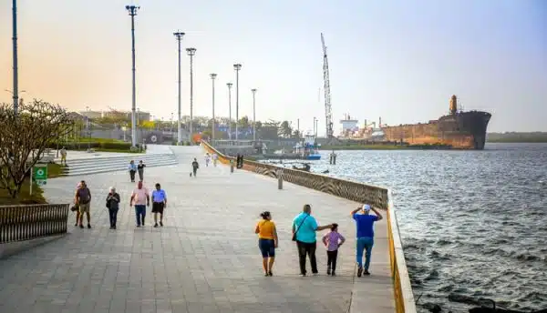 Visitantes disfrutan del atardecer en el Malecón del Río en Barranquilla, junto al majestuoso Río Magdalena.