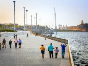 Visitantes disfrutan del atardecer en el Malecón del Río en Barranquilla, junto al majestuoso Río Magdalena.