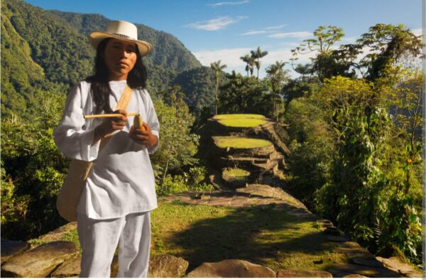 indigena posando para la camara. al fondo la ciudad perdida en santa marta
